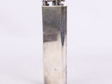 un briquet argenté posé sur une surface blanche