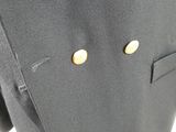 a close up of a black suit with gold buttons