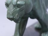 statue of a green tiger on a black marble base