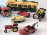 many toy cars and trucks that are on a white surface
