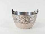an antique silver plated bowl with a handle on a white background