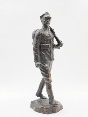 statue of a man in uniform holding a baseball bat on a rock