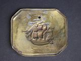 an image of a gold plate with a ship on it