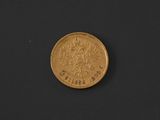 a close up of a gold coin on a black surface