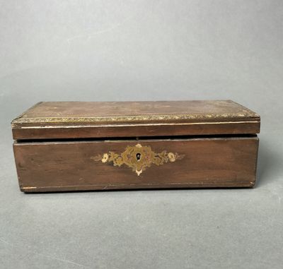 an old wooden box with a gold decoration on the lid
