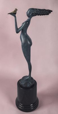 statue d'une femme tenant un oiseau, posée sur un socle noir