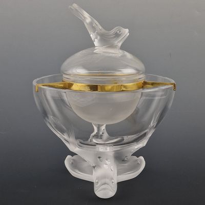 a glass bowl with a bird on top of it