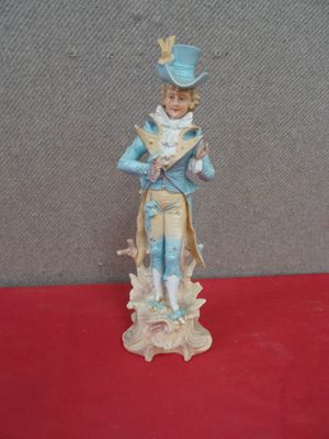 a figurine of a man in a blue suit and hat on a red surface