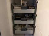 an image of a kitchen pantry with drawers and a refrigerator