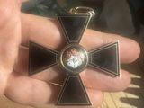a person holding a metal cross with a skull on it