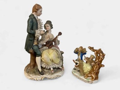two figurines of a man and a woman sitting on a bench