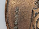 a close up of a metal plate with a clock on it