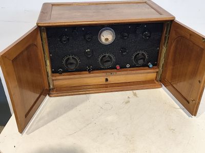 une radio à l'ancienne posée sur une table, dont les volets sont ouverts