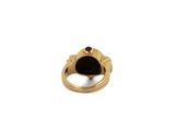 a close up of a gold ring with a black stone