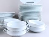 many white plates and bowls stacked on top of each other