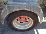 a flat tire on a flatbed truck parked in a parking lot