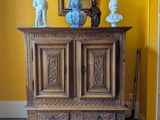 une armoire en bois dans une pièce, sur laquelle est posée une lampe