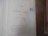 un livre ouvert sur une table, avec une horloge posée dessus