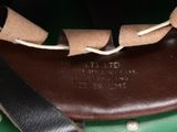 a close up of a brown and green bag with a black handle