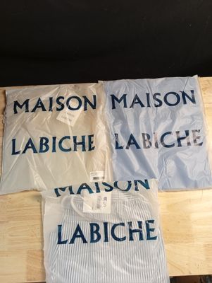 trois chemises posées sur une table, sur lesquelles figure un nom