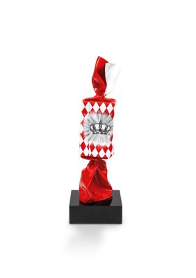 a red and white candy bag sitting on top of a black stand