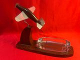 un cendrier en verre contenant un couteau, sur fond rouge