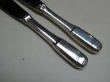 deux cuillères en argent et un couteau sur une table
