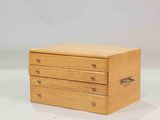 a small wooden box with three drawers on top of it
