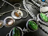 many different necklaces and bracelets that are on a table