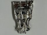 a silver pin with a train on it on a white surface