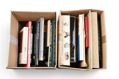 de nombreux livres dans une boîte en carton posée sur une surface blanche