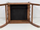 a small wooden table with a black cloth on it