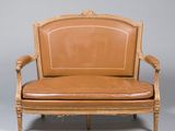 une image représentant un fauteuil en cuir marron sur fond gris