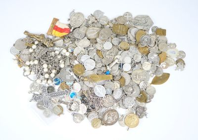 un tas de pièces d'argent et d'or posées sur une surface blanche