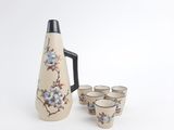 quatre tasses et un pichet posés les uns à côté des autres
