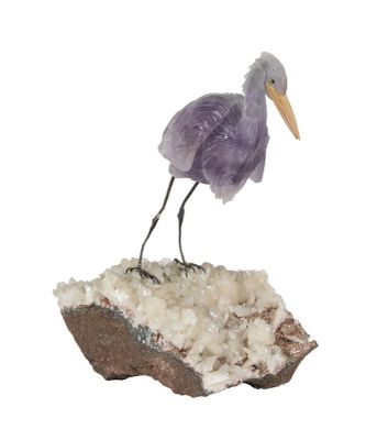 une figurine représentant un oiseau perché sur un rocher