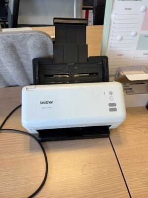 une imprimante posée sur un bureau à côté d'un écran