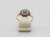 gros plan d'une bague en or et diamants sur une surface blanche