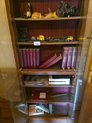 une vitrine en verre contenant des livres, dans une pièce