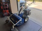 a small blue machine that is sitting on the sidewalk