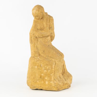 l'image d'une statue de femme assise sur un rocher