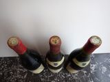 three bottles of wine are lined up on a counter top