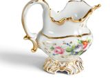 a close up of a white and gold vase with flowers on it