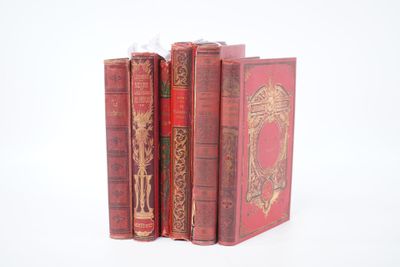 trois livres rouges superposés sur une surface blanche