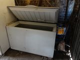a white chest freezer sitting in the corner of a room