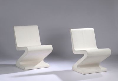 two white chairs sitting next to each other on a white surface