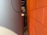 an image of a bathroom with a toilet and a red brick wall
