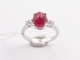 an oval ruby and diamond ring on a white background