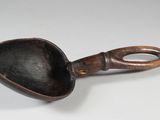 a close up of a spoon with a handle on a white surface