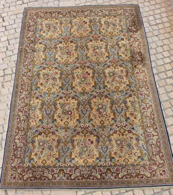 un tapis persan ancien posé sur un sol pavé